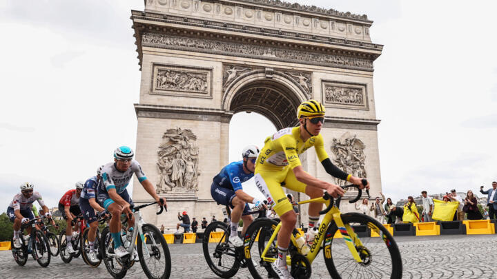 Slovenian rider Tadej Pogacar wearing the overall leader's yellow jersey cycles past the Arc de Triomphe during the 21st and final stage of the Tour de France, on July 27, 2025.
