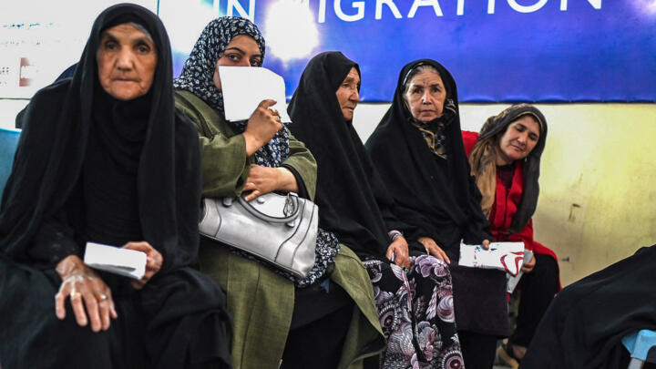 Afghan refugee women, who were deported from Iran, wait to receive money at a registration centre of the International Organisation for Migration (IOM) in Herat on June 28, 2025. 