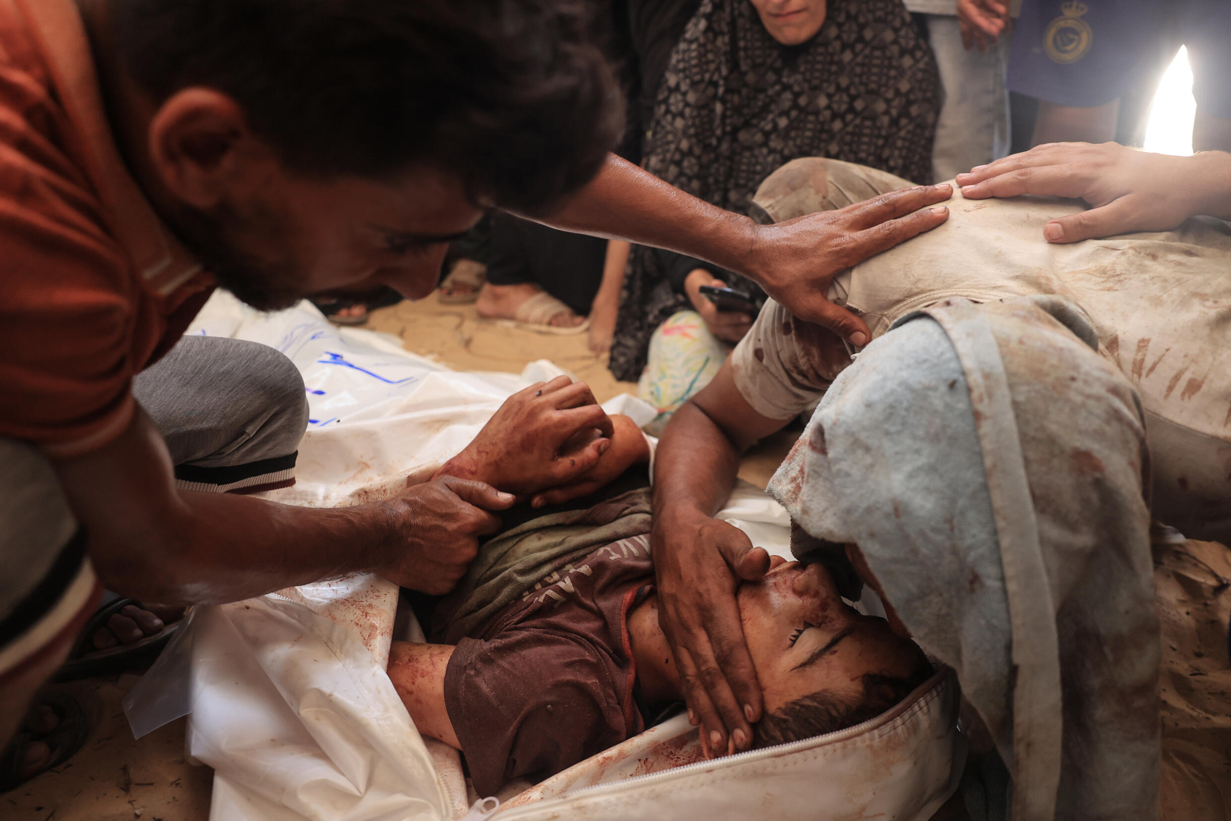 Un corps se trouve sur le sol devant la morgue de l'hôpital Nasser à Khan Younès, l'un des établissements vers lesquels les victimes ont été transportées après qu'une frappe imputée à Israël dans le camp d'Al-Mawasi, dans le sud du territoire palestinien, le 13 juillet 2024