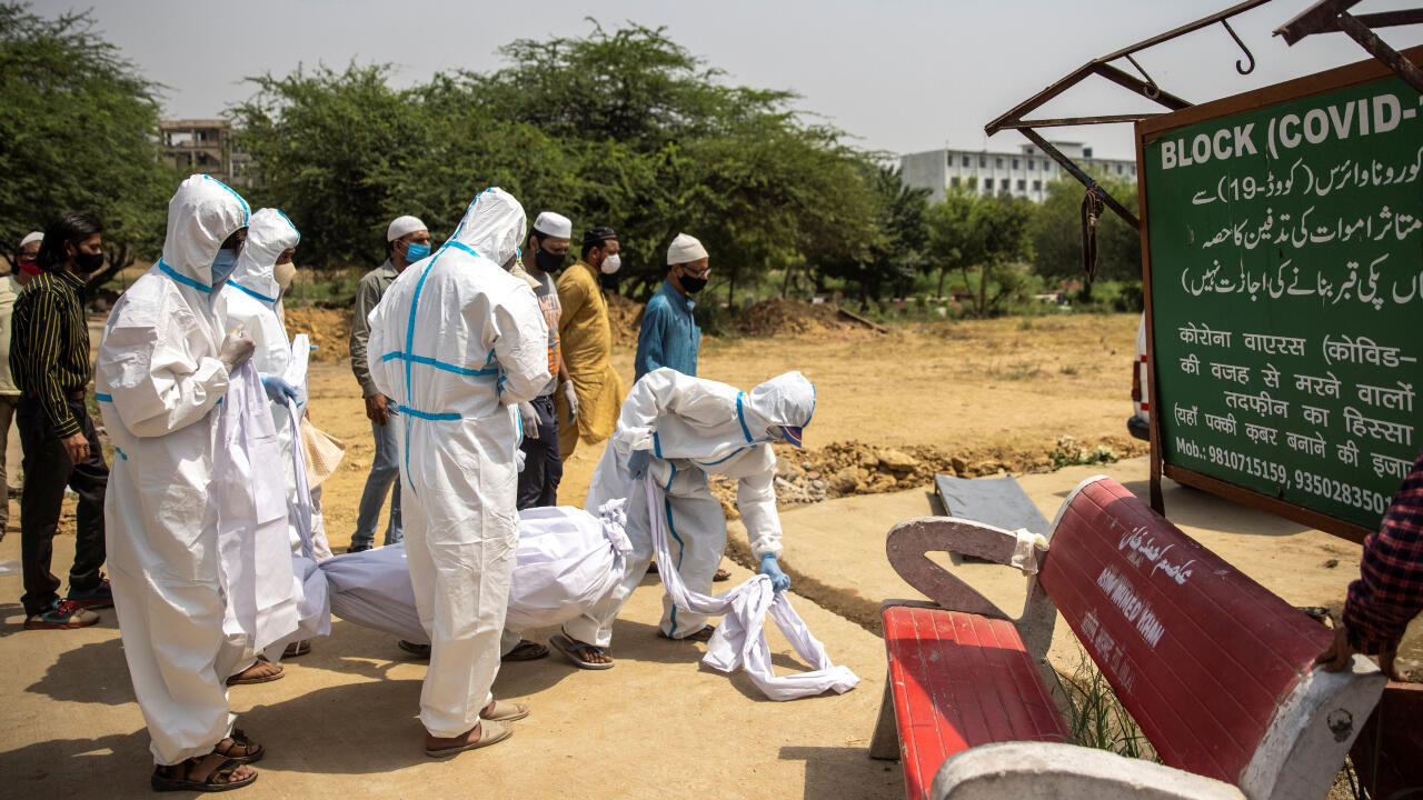 Covid-19: cerca de 15 millones de personas murieron por el virus, casi el triple de lo estimado 2 Archivo-Personal sanitario y familiares cargan el cuerpo de una persona que falleció por Covid-19 en Nueva Delhi, India, el 28 de abril de 2021.