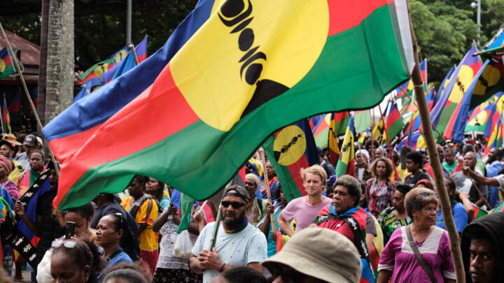Des indépendantistes tenant des drapeaux kanaks, le 13 avril 2024 à Nouméa, lors d'une manifestation contre l'élargissement du corps électoral en Nouvelle-Calédonie.