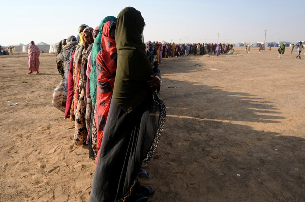 Mujeres desplazadas hacen una larga cola para recibir alimentos en un campamento de desplazados en Al-Dabbah, Sudán, el 13 de noviembre de 2025.
