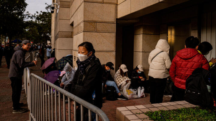 People wait in line outside the West Kowloon Law Courts building to hear the verdict in the national security trial of pro-democracy media tycoon Jimmy Lai in Hong Kong on December 15, 2025.