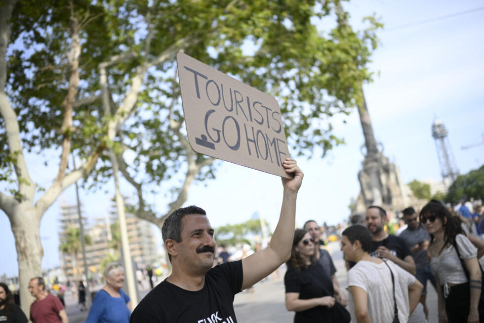 A protester uses a megaphone as people protest against mass tourism, in Alicante, Spain, July 13, 2024.