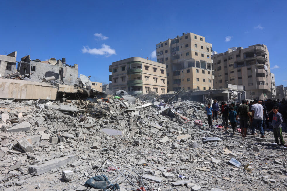Des Palestiniens inspectent les décombres d'une maison détruite par une frappe israélienne dans la ville de Gaza, le 19 mars 2025.