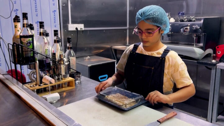 A participant in the 'Baghdad Gate' project to provide jobs for orphans prepares food at a kiosk in Baghdad.