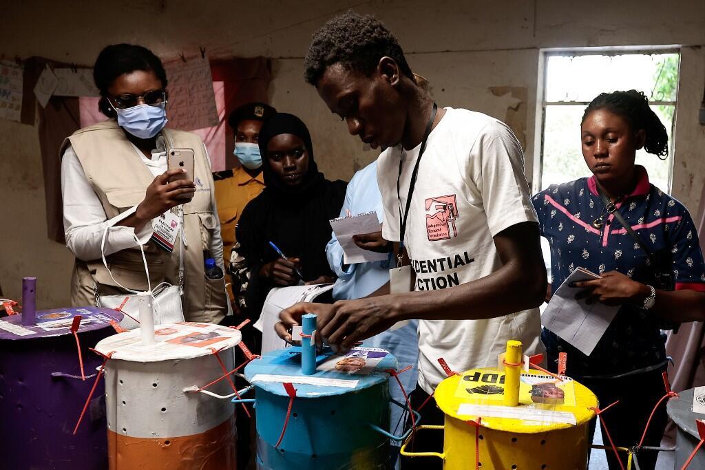 Un miembro del personal de una mesa de votación sella las urnas, en las que se vota con un sistema de canicas, para el recuento de papeletas después de las elecciones presidenciales, en Banjul, Gambia. 4 de diciembre de 2021.