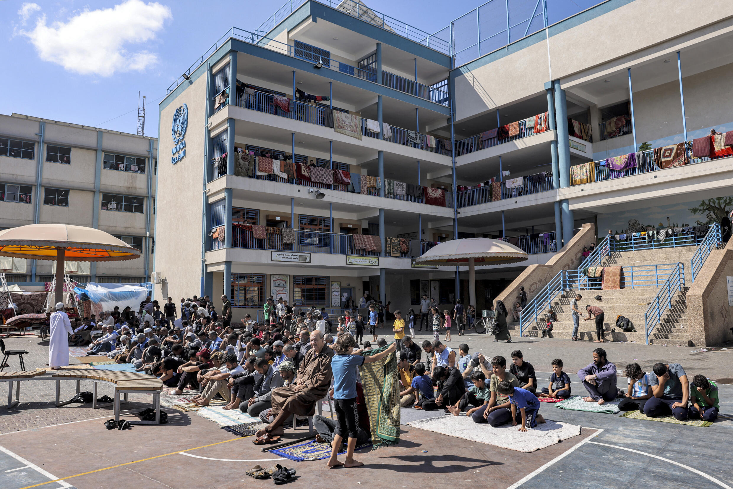 Les Palestiniens se rassemblent pour la prière hebdomadaire du vendredi dans la cour de récréation d'une école gérée par l'Office de secours et de travaux des Nations Unies pour les réfugiés de Palestine (UNRWA) à Rafah, dans le sud de la bande de Gaza, le 20 octobre 2023.