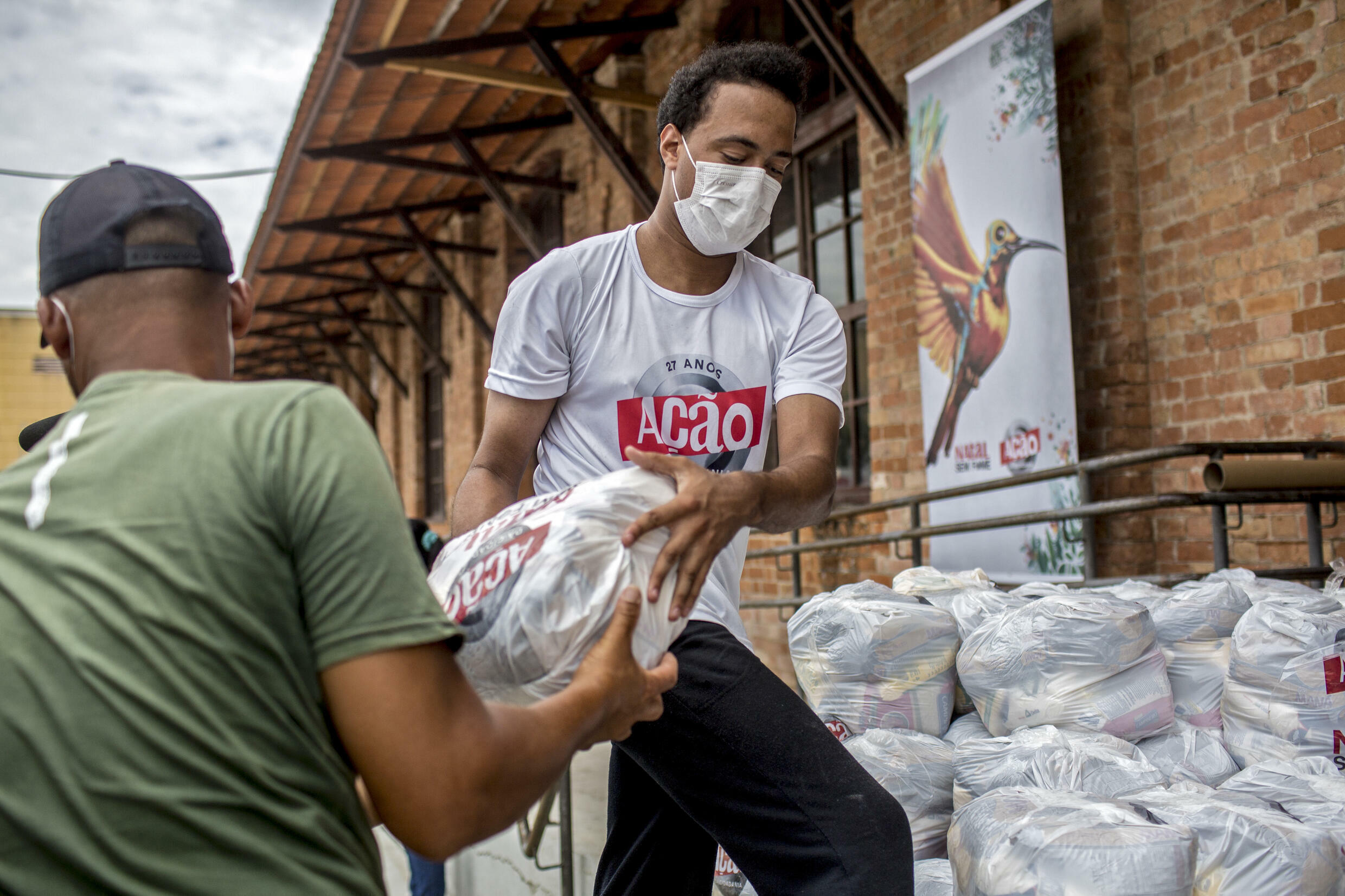 Des bénévoles chargent des colis alimentaires dans un camion
