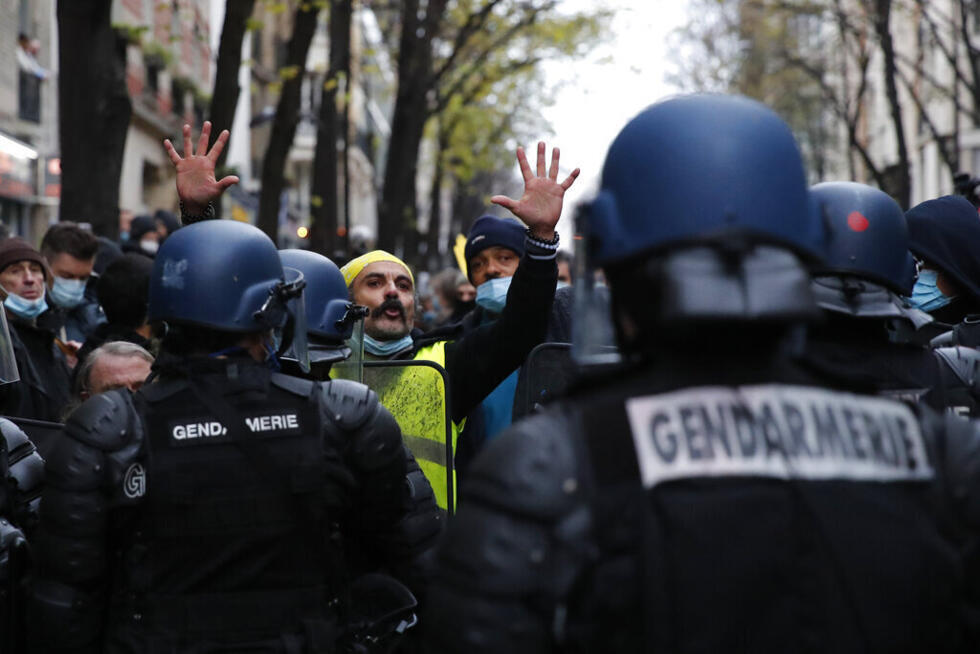 Un manifestante con chaleco amarillo levanta las manos durante una manifestación el sábado 5 de diciembre de 2020 en París. La mala conducta policial ha recibido mayor atención en Francia tras la publicación de imágenes el mes pasado de policías franceses golpeando a un hombre negro, lo que desató una protesta nacional.