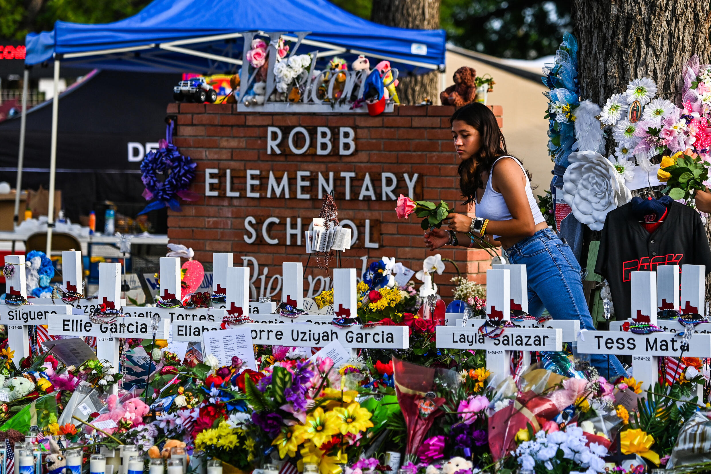 Archivo. Una niña deposita flores en un monumento improvisado en la Escuela Primaria Robb en Uvalde, Texas, el 28 de mayo de 2022. Familiares de niños asesinados o heridos por un tiroteo masivo en Uvalde hace dos años llegaron a un acuerdo de $ 2 millones con Texas ciudad, dijo un abogado de las familias el 22 de mayo de 2024. Diecinueve niños pequeños y dos maestros murieron cuando un pistolero adolescente atacó la escuela primaria Robb en mayo de 2022.