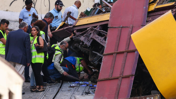 People work at the site of the accident after Gloria funicular railway car, a popular tourist attraction, derailed and crashed, resulting in multiple casualties, according to authorities, in Lisbon, P