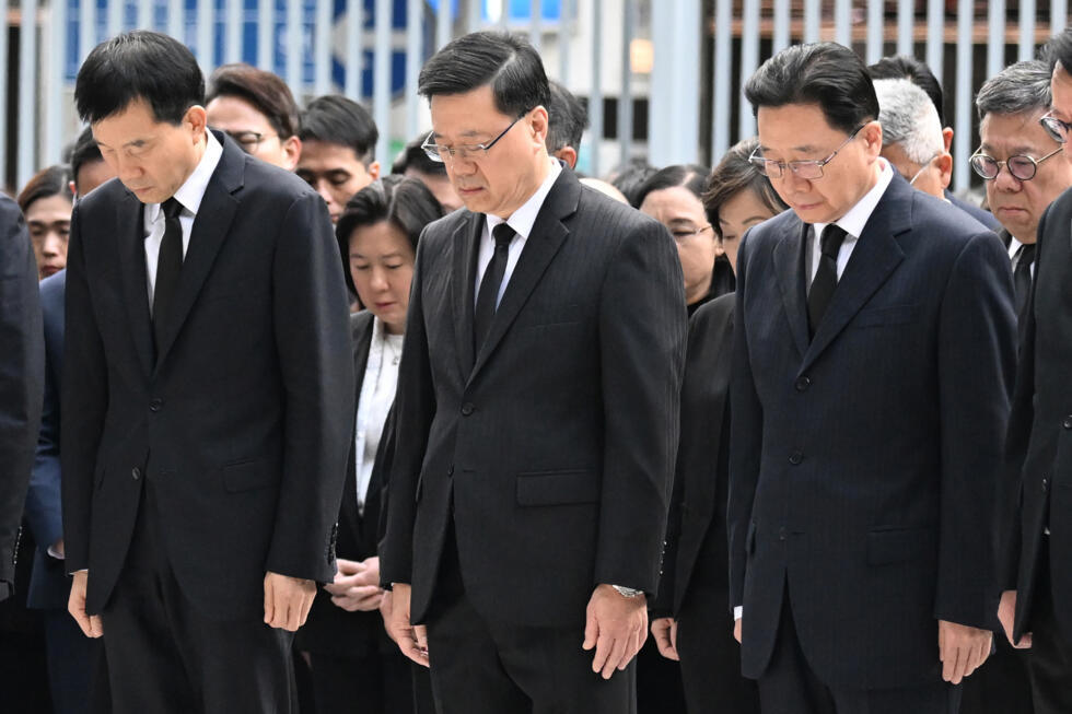 Hong Kong's Chief Executive John Lee (C) and other government officials observe three minutes of silence to mourn victims of the Wang Fuk Court residential estate fire.