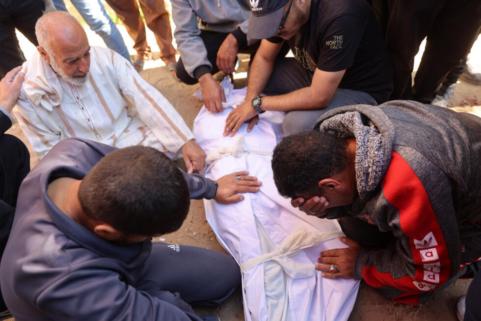 Des personnes pleurent sur le corps d'une victime de bombardements israéliens à Beit Lahia, dans le nord de la bande de Gaza, le 15 mars 2025