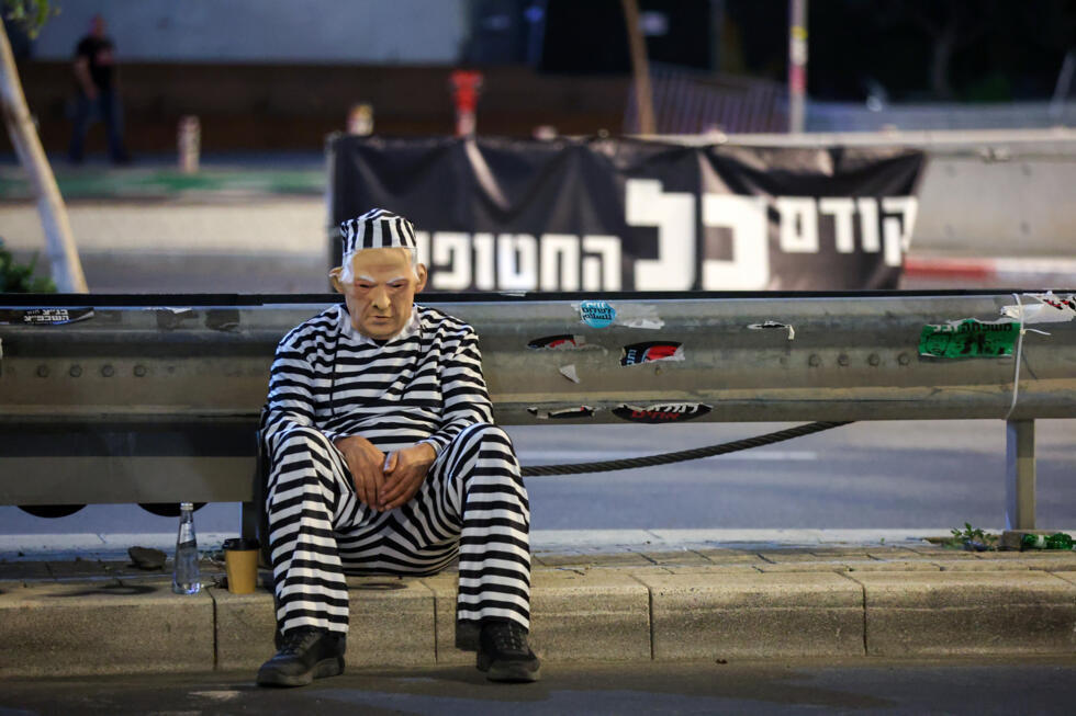 Un manifestant porte un masque représentant le Premier ministre israélien Benjamin Netanyahu vêtu d'un uniforme de prisonnier lors d'une manifestation appelant à la libération des otages dans la bande de Gaza,  à Tel-Aviv, le 15 mars 2025
