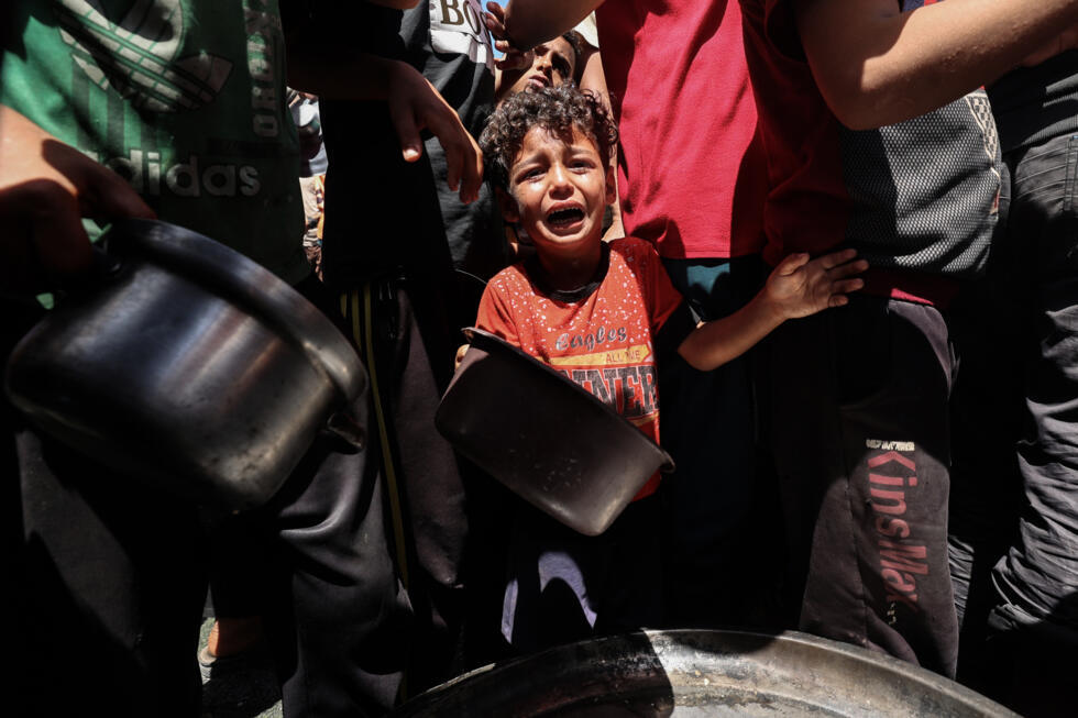Lors d'une distribution de nourriture dans le camp de Nousseirat, dans le centre de la bande de Gaza, le 23 mai 2025