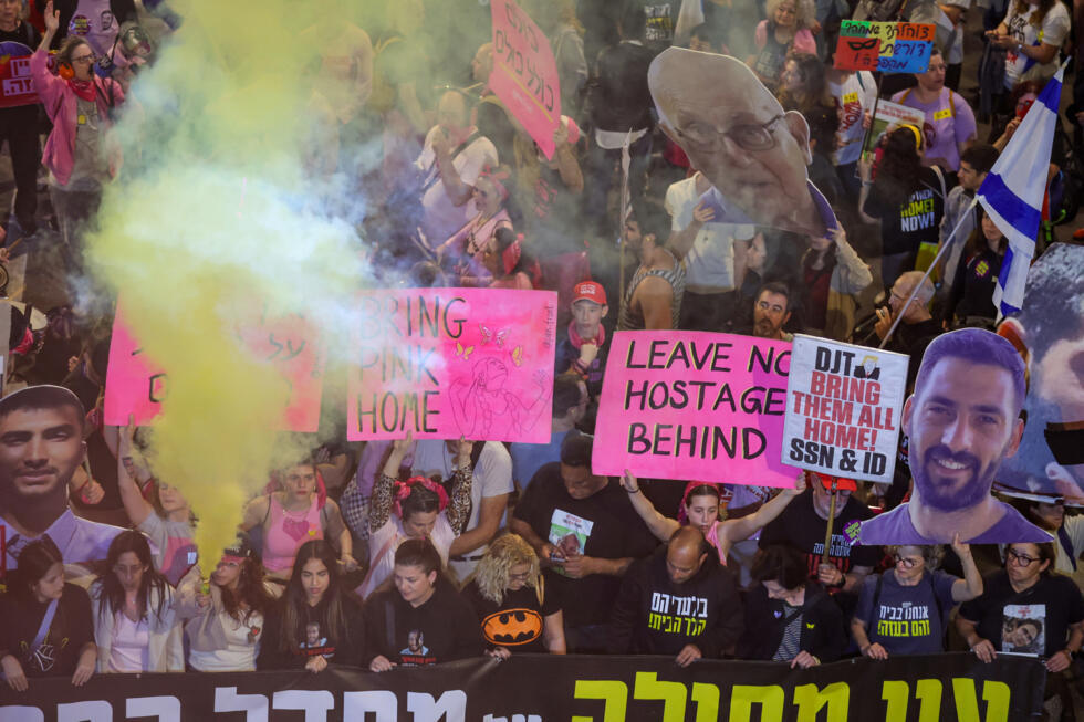 Des manifestants brandissent des pancartes et lancent des fusées éclairantes lors d'une manifestation appelant à la libération des otages encore retenus dans la bande de Gaza, à Tel-Aviv, le 15 mars 2025