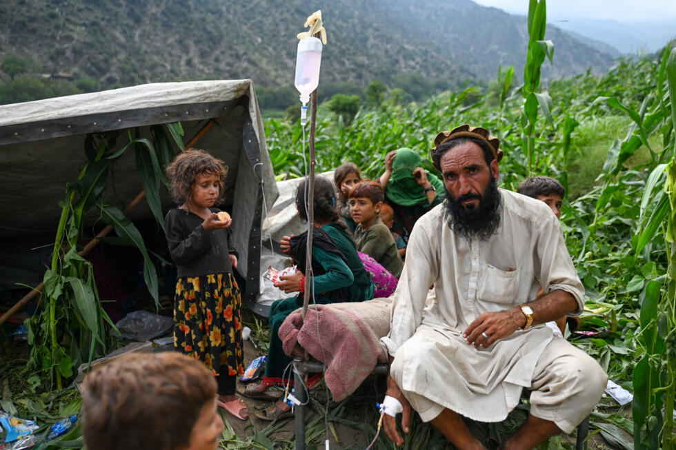 Un Afghan blessé reçoit une perfusion dans un champ de maïs à la suite de séismes dans le village de Mazar Dara, situé dans le district de Nurgal, dans l'est de l'Afghanistan, le 1er septembre 2025.