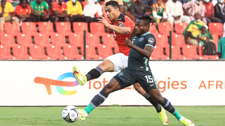 Egypt's forward Mostafa Mohamed (L) fights for the ball with Nigeria's forward Moses Simon during the Group D Africa Cup of Nations (CAN) 2021 football match between Nigeria and Egypt at Stade Roumde Adjia in Garoua on January 11, 2022.