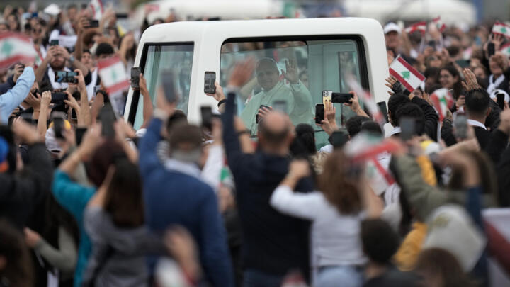 Pope Leo XIV greets the crowd upon his arrival to celebrate Mass on the seafront in Beirut on December 2, 2025.