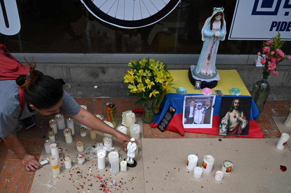 Une femme allume des bougies devant la clinique Santa Fe, où le sénateur Miguel Uribe est hospitalisé après avoir été blessé par balle lors d'un meeting politique, le 10 juin 2025 à Bogota, en Colombie