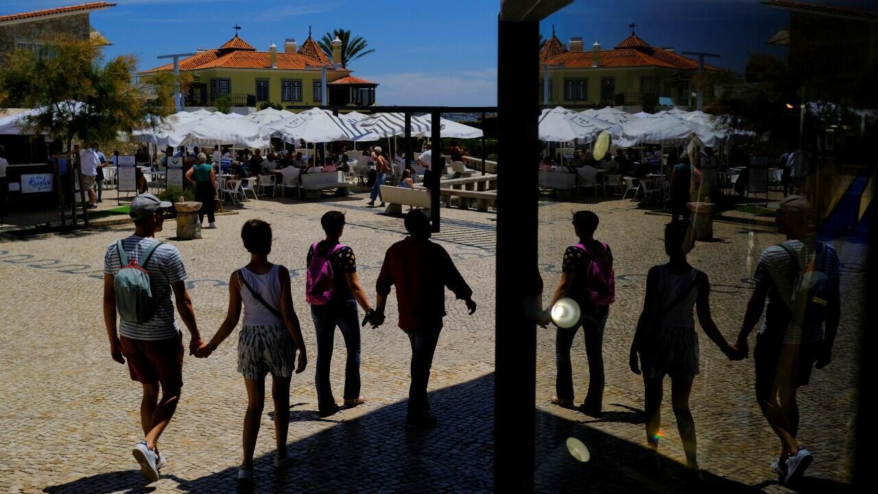 Archivo-Algunas personas caminan cerca a una tienda en Cascais, Portugal, el 6 de junio de 2022.