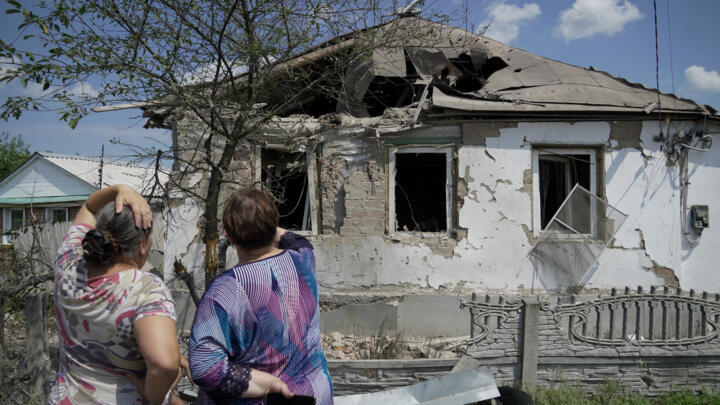 Women look at a house destroyed by recent Ukrainian strikes in the town of Valuyki, near the border with Ukraine in Russia's Belgorod region, on July 5, 2023. 