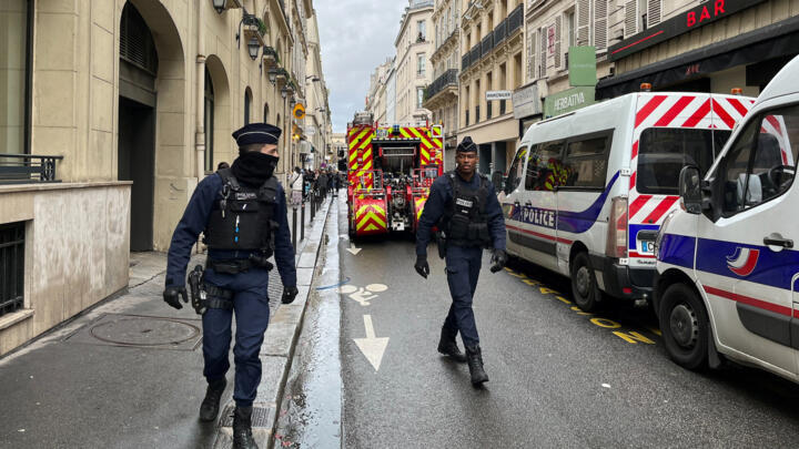 French police and firefighters secure a street in central Paris after Friday's deadly shooting.