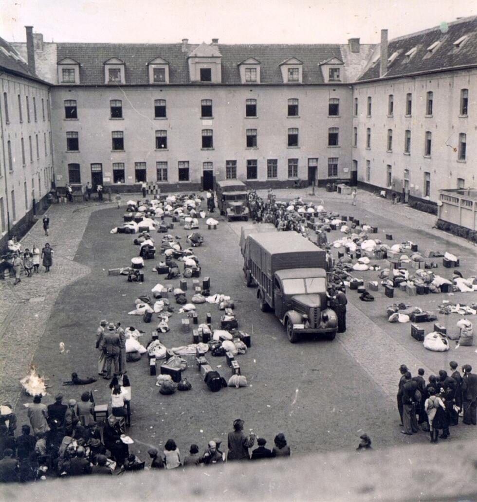 La cour intérieure du camp de transit de Malines, dans l'ancienne caserne militaire Dossin, en banlieue de Bruxelles, en Belgique, avec deux camions de transport pour des détenus juifs, en 1942.