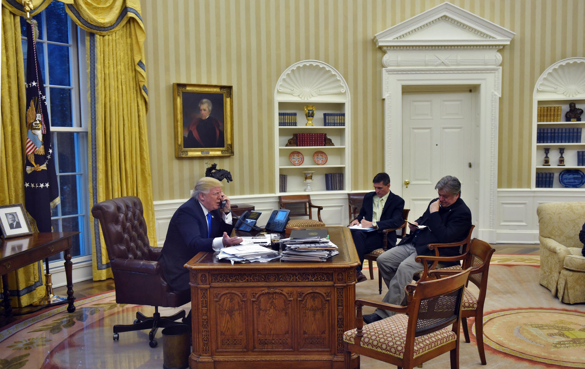 En esta foto de archivo tomada el 28 de enero de 2017, el presidente de los Estados Unidos, Donald Trump, habla por teléfono con el primer ministro de Australia, Malcolm Turnbull, junto con Steve Bannon (der.) y el asesor de seguridad nacional Michael Flynn, de la Oficina Oval de la Casa Blanca.