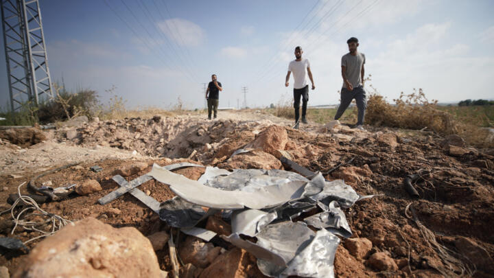 Palestinian men walk towards a crater and debris caused by an improvised explosive device which targeted an Israeli military jeep in the northern Palestinian city of Jenin in the occupied West Bank.