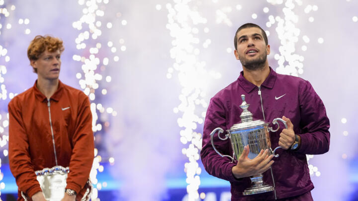 Carlos Alcaraz, of Spain, holds the championship trophy as Jannik Sinner, of Italy, looks on after Alcaraz defeated Sinner in the men's singles final of the U.S. Open on Sunday, Sept. 7 in NY.