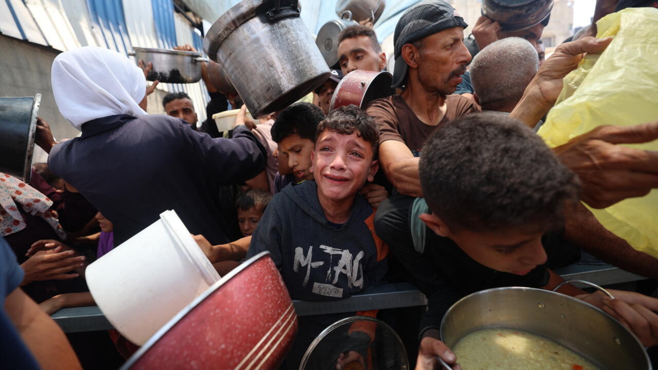 Niños palestinos esperan comida en un punto de distribución en Nuseirat, en el centro de la Franja de Gaza, el 11 de junio de 2025.