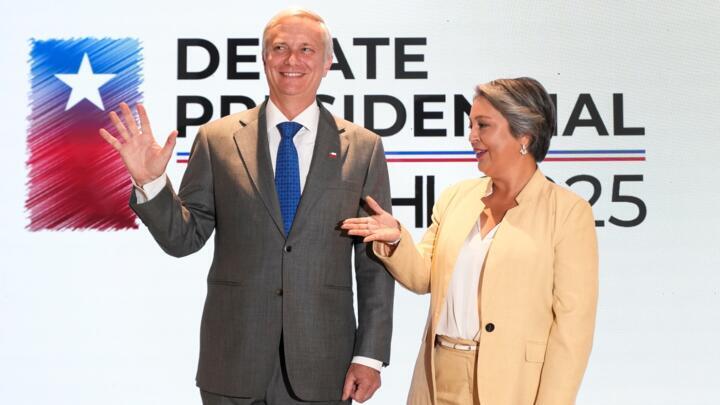 Presidential candidates Jose Antonio Kast, of the Republican party, and Jeannette Jara, of the Unity for Chile coalition party, pose for a photo during their debate in Santiago, Chile, December 3, 202