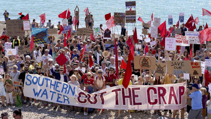 Members of the public and protesters from Hastings and St Leonards Clean Water Action, protest against raw sewage release incidents on the beach in St Leonards, Britain, Friday Aug. 26, 2022.