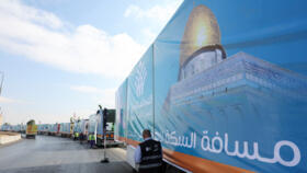 A long line of trucks loaded with humanitarian aid wait at the Rafah border crossing to enter Gaza, Egypt, on October 16, 2025.