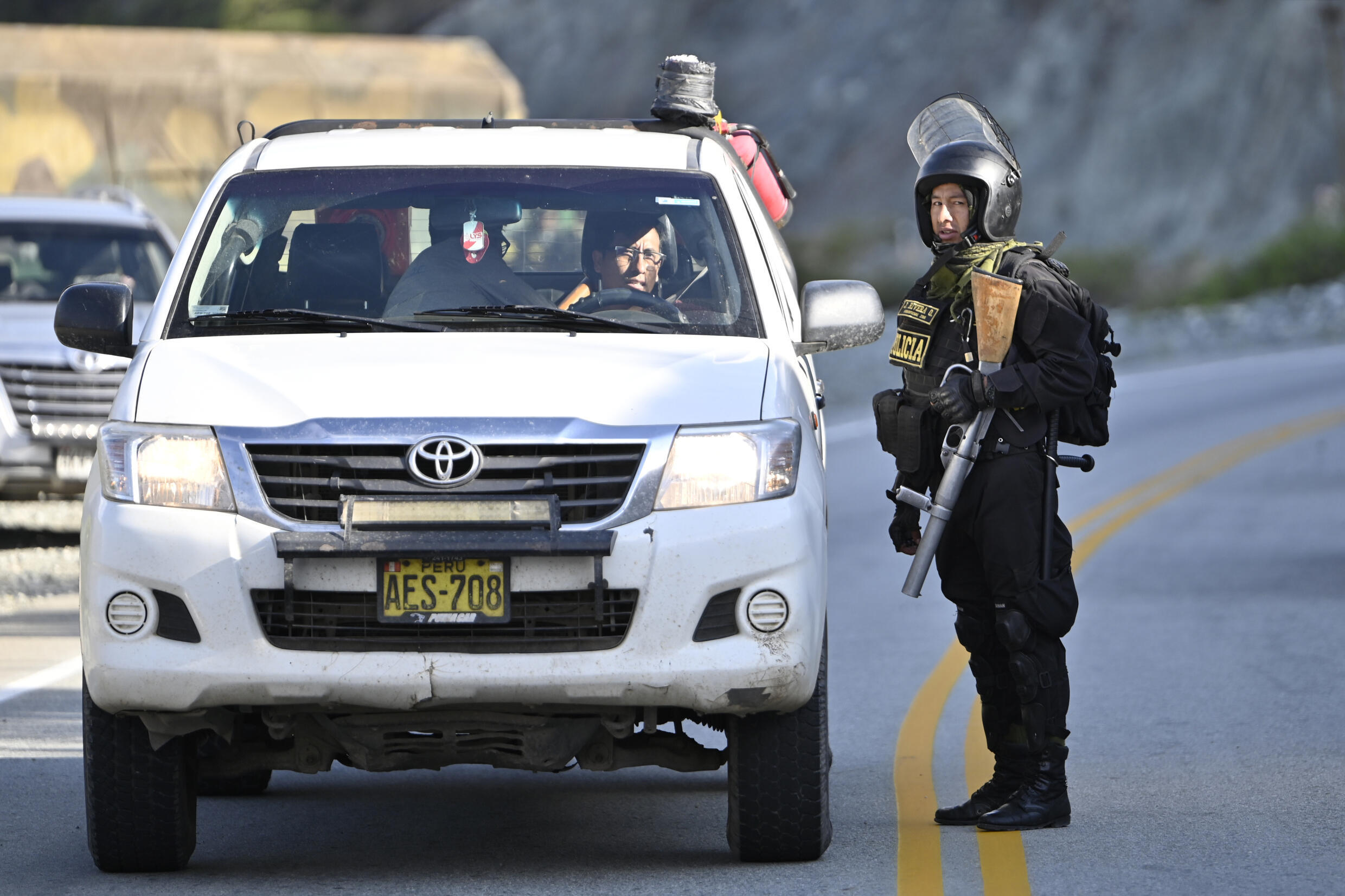 Policjant patroluje autostradę, aby uniemożliwić chłopom i przywódcom społeczności sympatyzującym z byłym prezydentem Pedro Castillo przeprowadzenie blokady przy wjeździe do Abancay w Peru, 19 grudnia 2022 r.