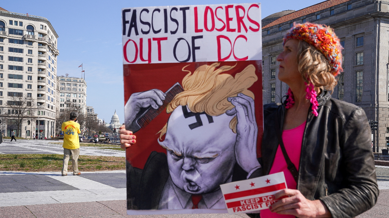 Una mujer sostiene una pancarta durante una manifestación organizada contra la llegada de varios convoyes de camioneros a Washington, en Washington, Estados Unidos, el 5 de marzo de 2022.