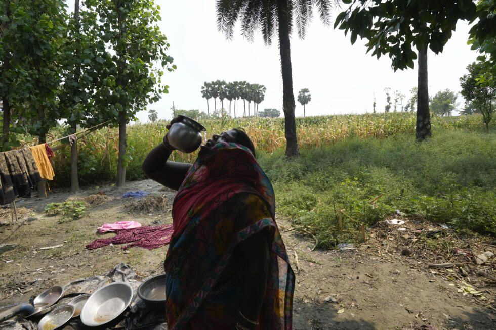 Rekha Devi, esposa de Tuntun Sada, un trabajador, bebe agua fuera de su choza, en una aldea a las afueras de Samastipur, en el estado indio de Bihar, el 12 de mayo de 2024.