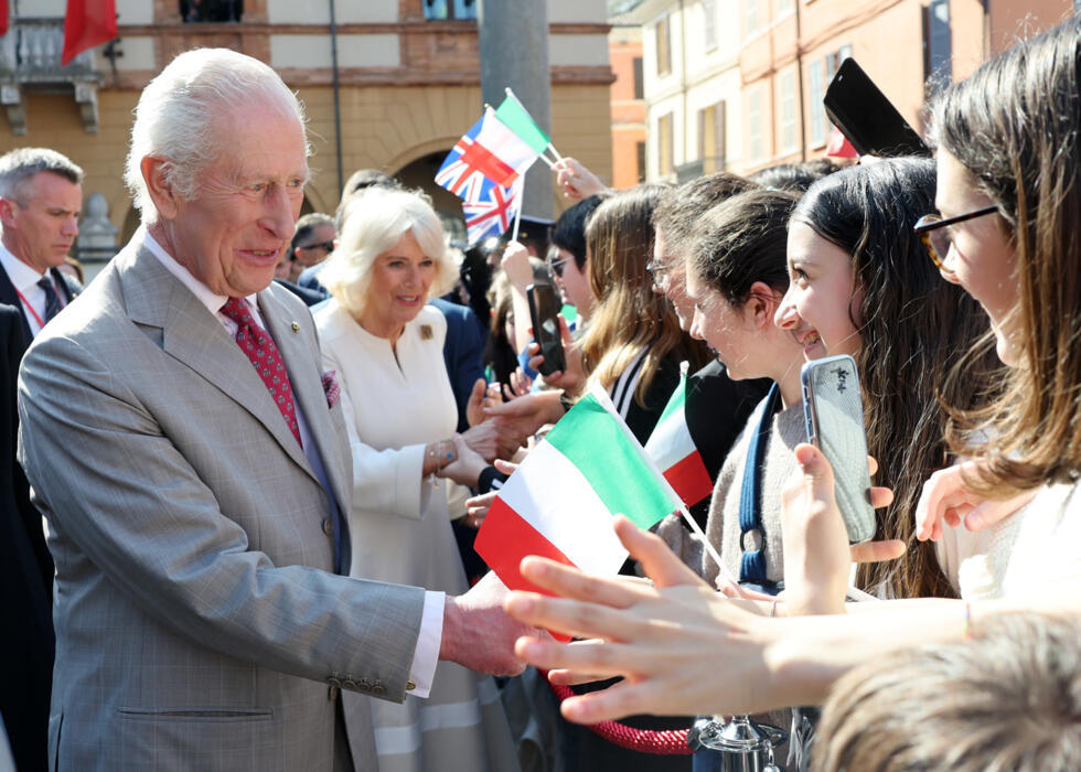 El rey Carlos III y la reina Camila saludan a la multitud durante una visita a un mercado en la Piazza del Popolo en Rávena, el último día de una visita de estado a Italia, el 10 de abril de 2025.