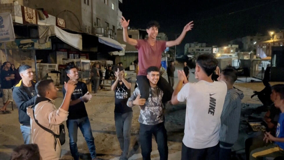 Jóvenes palestinos celebran en las calles de Khan Younis, luego de conocer sobre la firma de los acuerdos. 9 de octubre de 2025.
