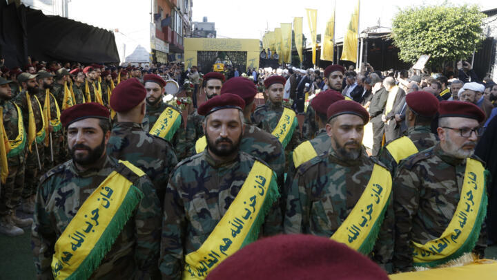 Hezbollah fighters stand in front of the flag-draped coffin of Mohammed Srur, the movement's head of the drone unit, on September 27, 2024.
