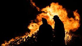 Two farmers in front of a lighted fire during a rally against the signing of a free trade agreement between the European Union and Mercosur countries, in Dijon on November 18, 2024.