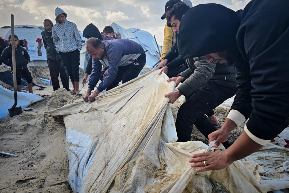 Palestinians try to recover their tent after overnight rainfall flooded their beachside tent camp in Khan Younis, in the southern Gaza Strip.