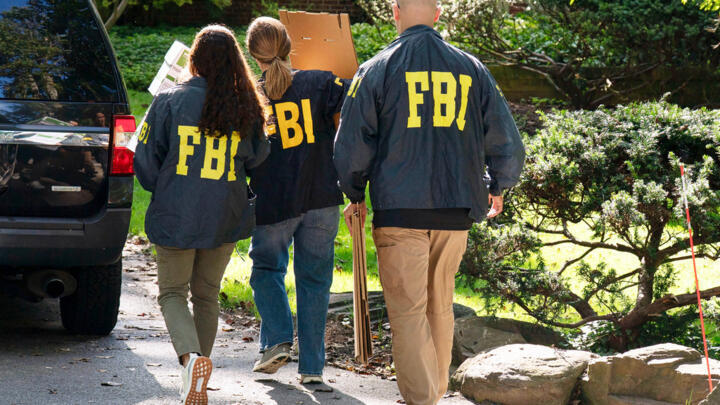 FBI agents carry empty boxes to former national security adviser John Bolton's house, August. 22, 2025, in Bethesda, Maryland.