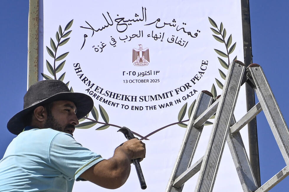 Un employé municipal installe un panneau à Charm el-Cheikh, dans l'est de l'Egypte, qui se prépare à accueillir un 'sommet pour la paix' à Gaza parrainé par les Etats-Unis, le 12 octobre 2025