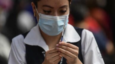 A nurse prepares a dose of the AstraZeneca vaccine against COVID-19 at a vaccination center in Mexico City