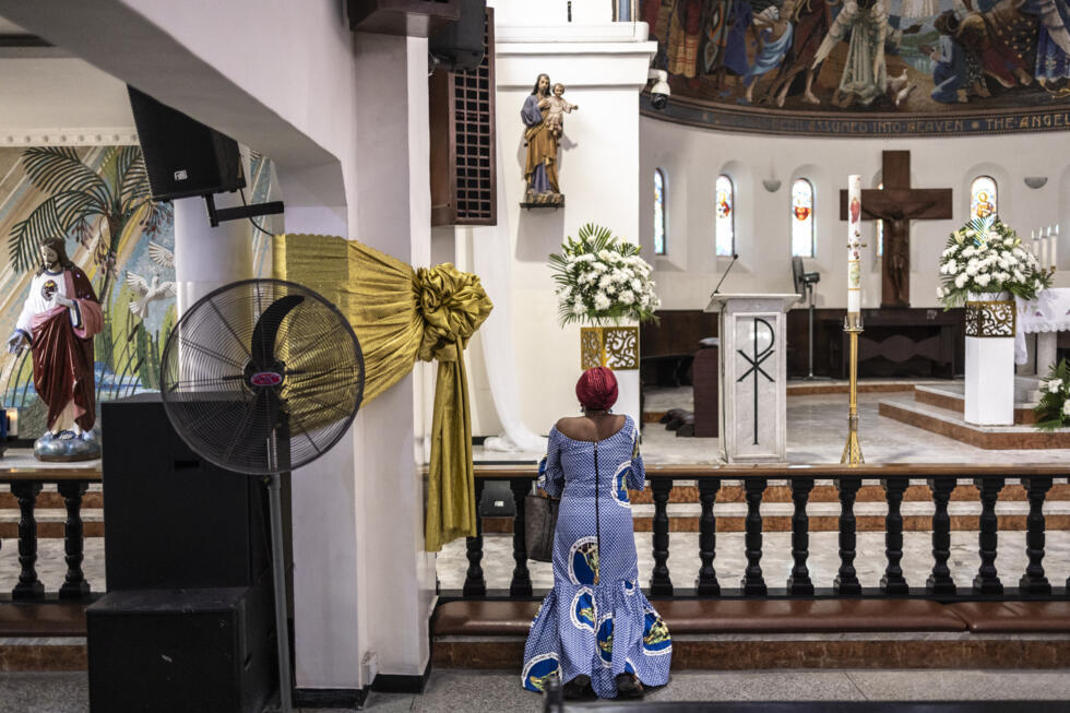 Un fidèle prie à l'église de l'Assomption à Lagos, au Nigeria, le 21 avril 2025, à l'annonce de la mort du pape François.