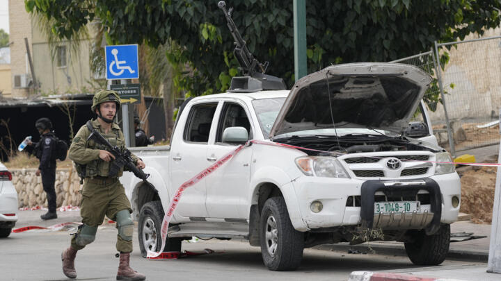 An Israeli soldier walks by a pickup truck used by Palestinian militants taken in Sderot, Israel, on October 7, 2023. 