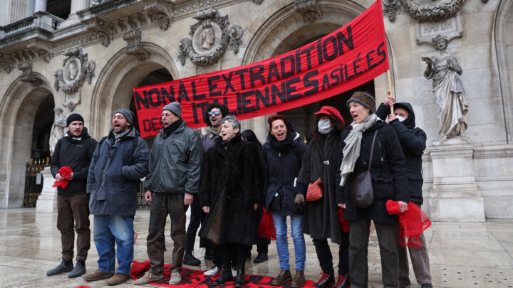 Protesters gather hold a banner to demonstrate against the extradition of the members of the Red Brigades detained in France, in Paris on April 1, 2022.